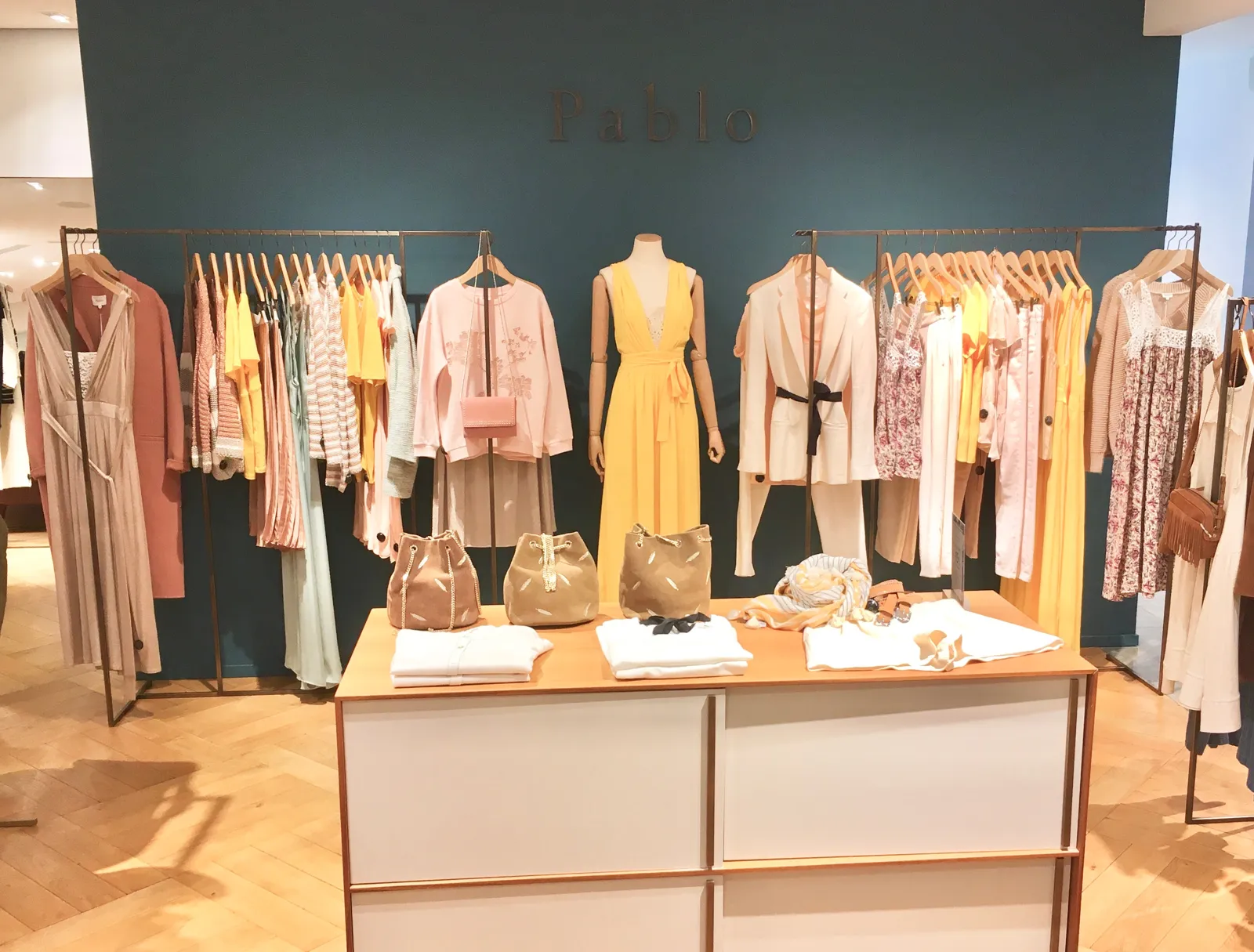 Mesa de producto con prendas dobladas por colores en una tienda de moda