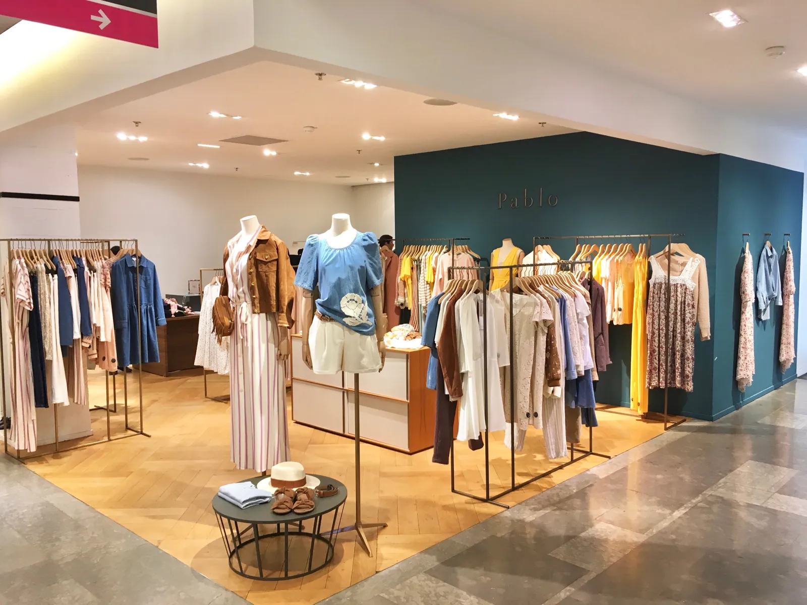 Sala de venta de una tienda de moda con mesa central de producto